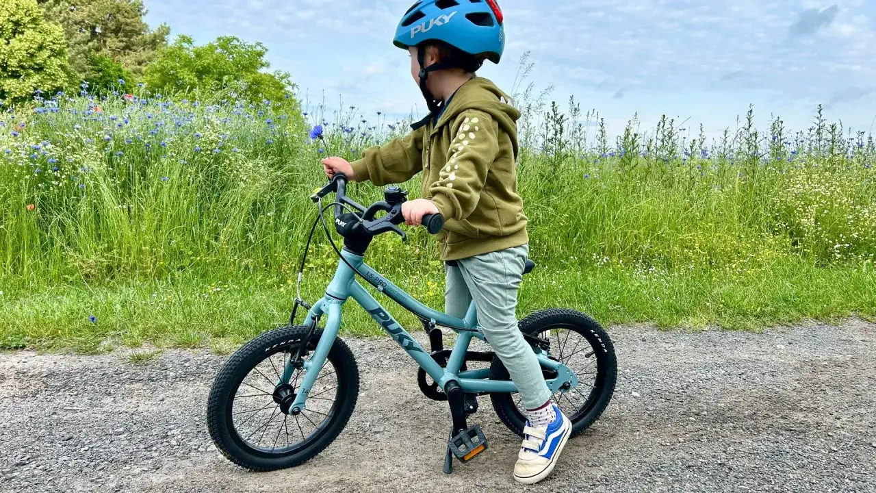 Kind auf Puky Fahrrad mit korrekt eingestelltem Sattel und Lenker